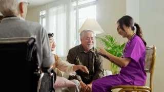 A nurse surrounded by happy patients in a care home environment