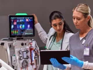 Two healthcare professionals discussing in front of monitor