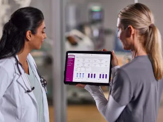 Two healthcare professionals discussing in front of a monitor