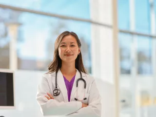 Healthare professional stands in front of a large window