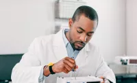 A man in a white coat repairs a medical device placed on a table